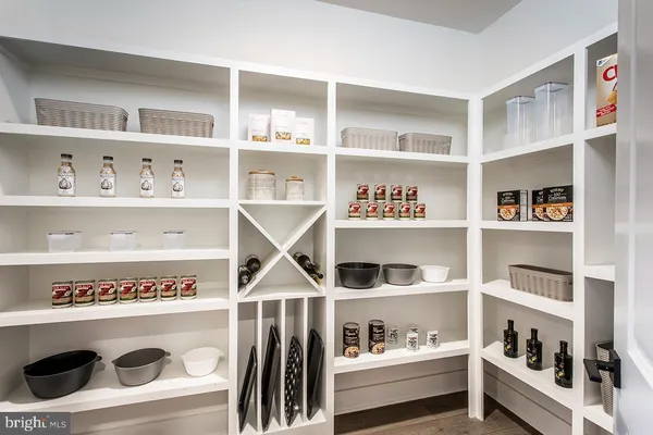 a view of kitchen cabinets with food and white countertops