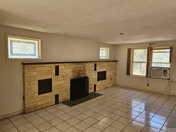 a view of empty room with fireplace and windows