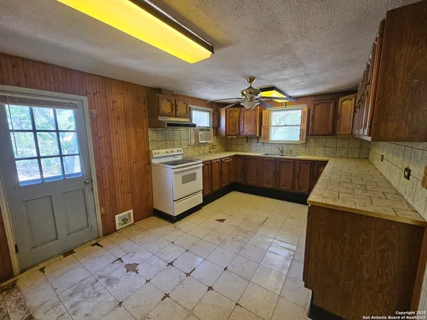 a kitchen with stainless steel appliances granite countertop a sink stove and cabinets