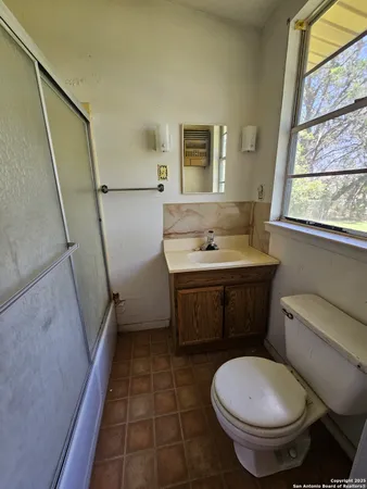 a bathroom with a sink toilet and window