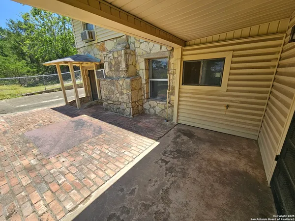 a backyard of a house with barbeque oven table and chairs