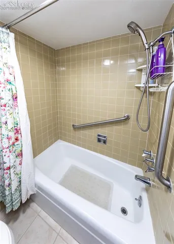 a bathroom with a bath tub with a shower