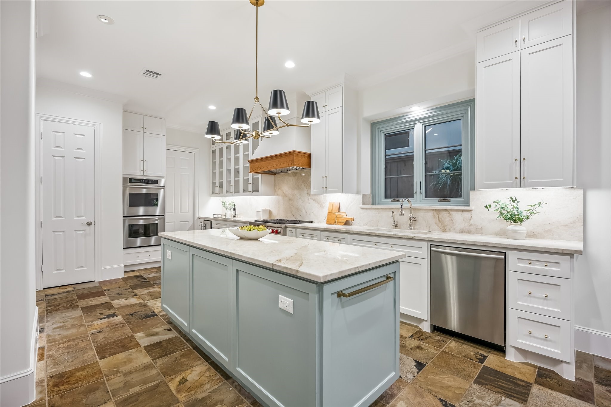 5034 Tangle Lane Houston, TX 77056 - Photo 12 of 50 At the center of the remodeled kitchen, an expanded contrasting island is topped in Taj Mahal stone and provides generous preparation, serving and gathering space, complemented by extensive custom cabinetry and layered lighting.