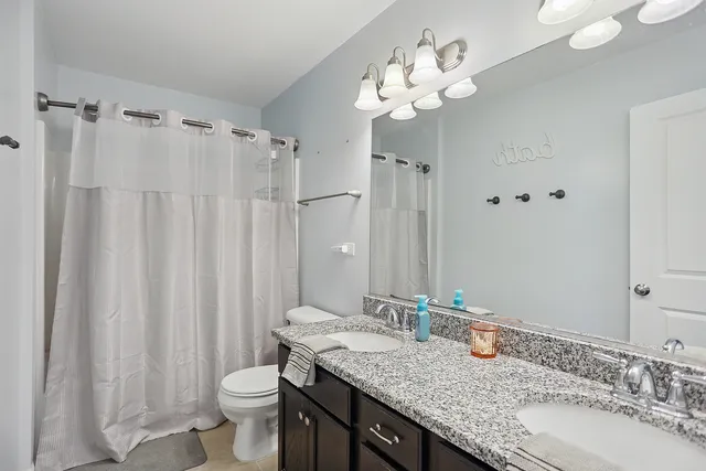 a bathroom with a granite countertop sink toilet and shower