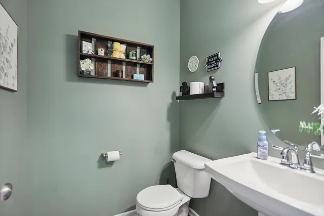 a bathroom with a toilet a sink and mirror