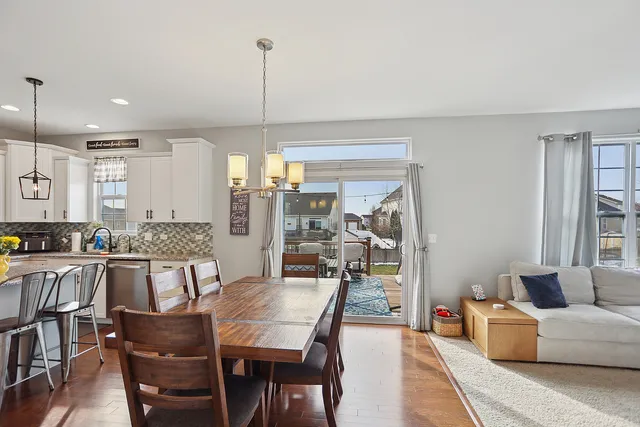 a dining room with furniture a chandelier and wooden floor