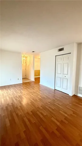 a view of a room with wooden floor and white walls