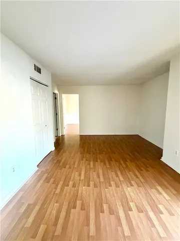 a view of a room with wooden floor and white walls