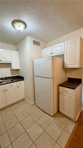 a kitchen with a refrigerator and a stove top oven