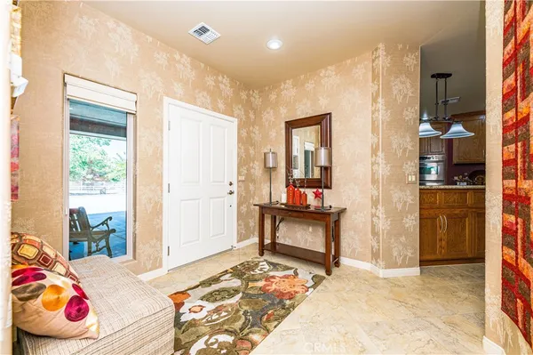 a living room with furniture kitchen view and a chandelier