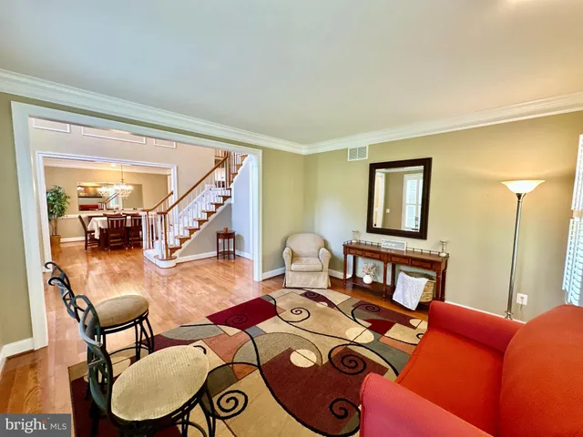 a kitchen with granite countertop a refrigerator a sink and chairs