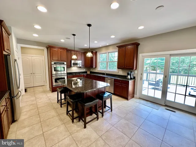 a kitchen with granite countertop a refrigerator and cabinets