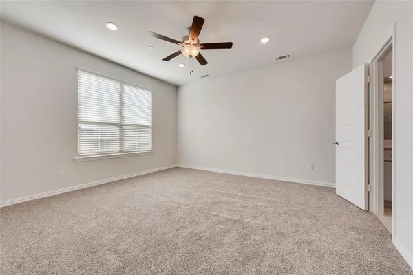 an empty room with windows and fan