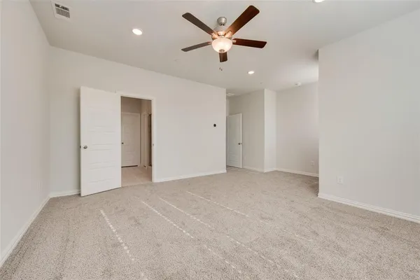an empty room with ceiling fan and window