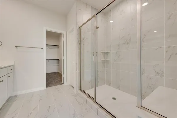 a bathroom with a shower and a glass door