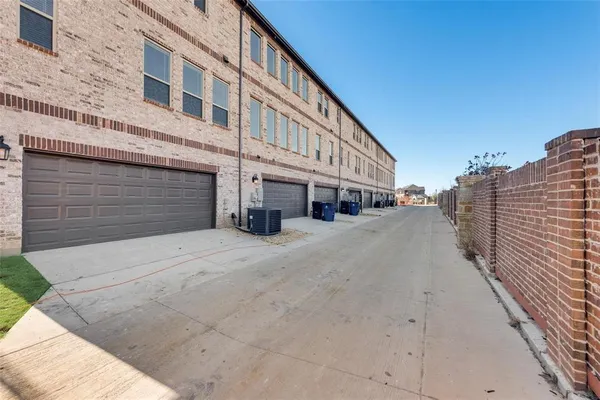 a front view of a building with streets and trees