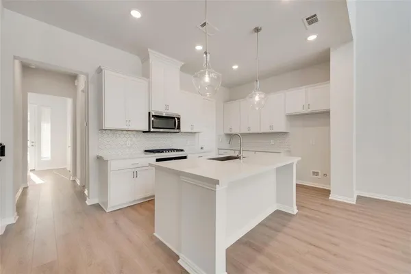 a kitchen with white cabinets and stainless steel appliances