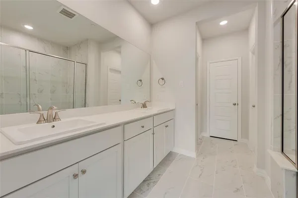 a bathroom with double sink and a mirror