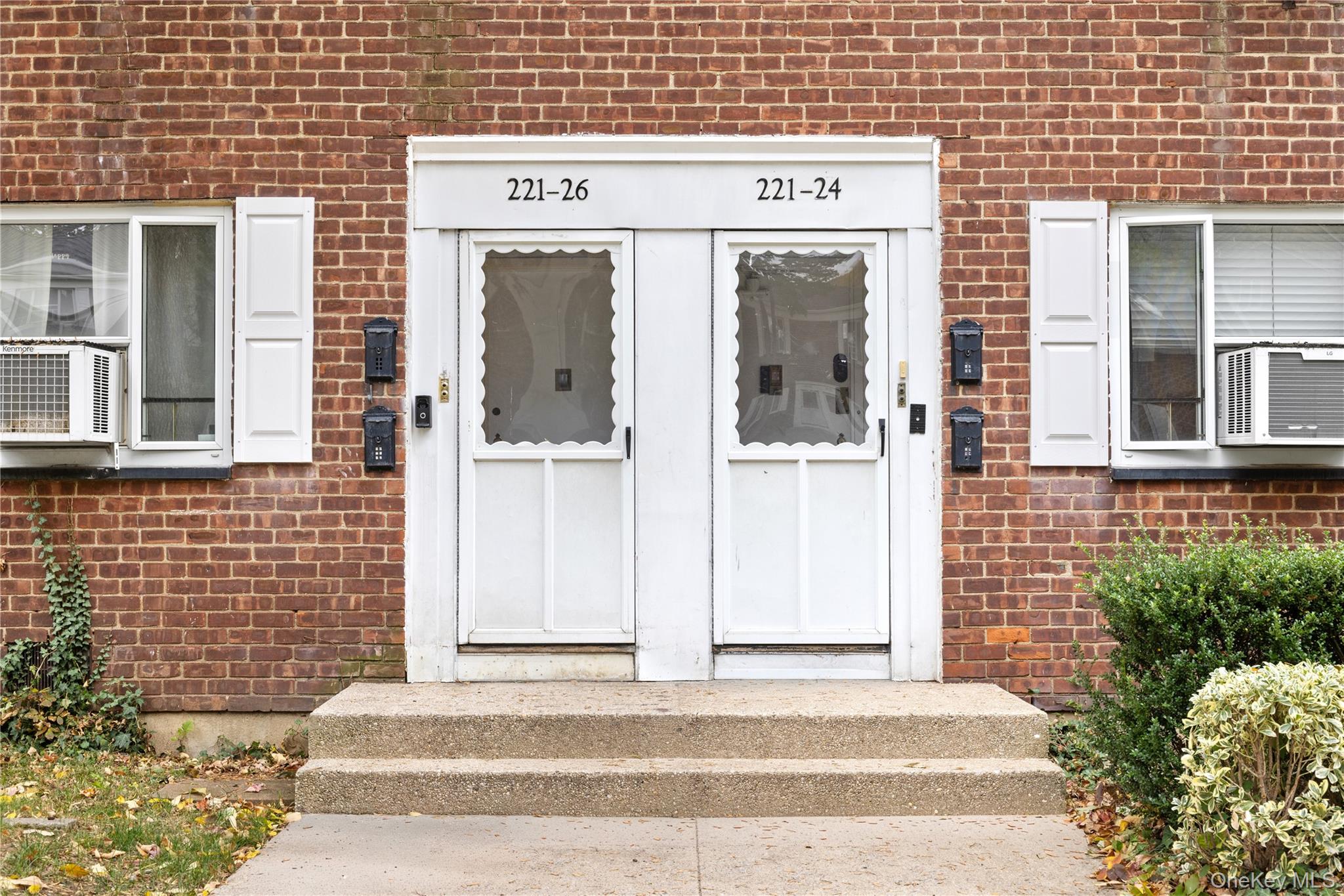 221-26 Manor Road, Unit 116 Queens, NY 11427 - Photo 2 of 19 a front view of a building with a garden