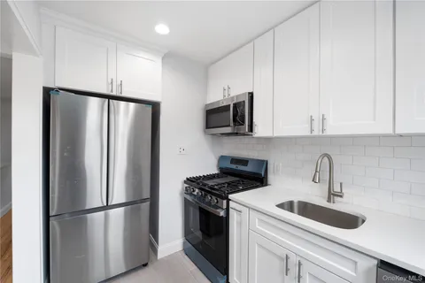 a kitchen with stainless steel appliances a refrigerator sink and microwave