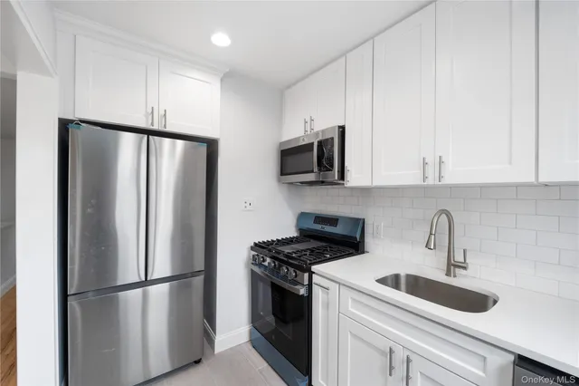 a kitchen with stainless steel appliances a refrigerator sink and microwave