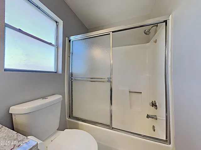 a white toilet sitting next to a shower