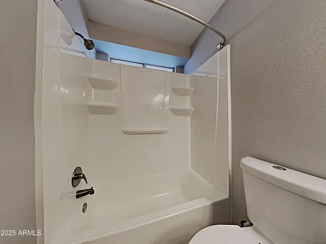 a bathroom with a shower a toilet and a bathtub