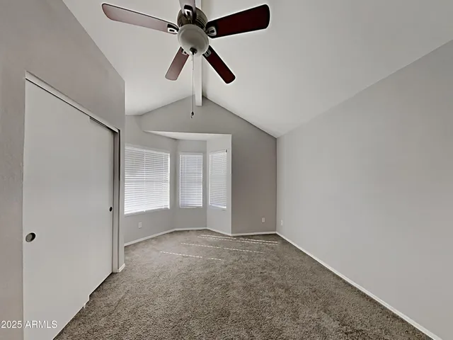 an empty room with chandelier fan
