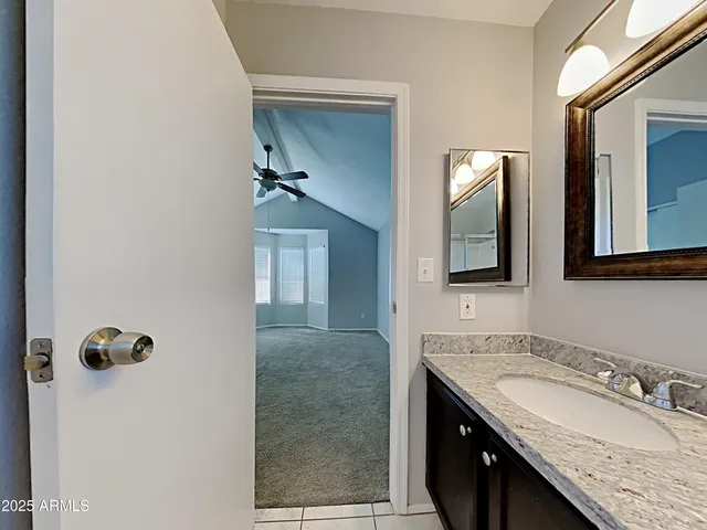 a bathroom with a granite countertop sink and mirror