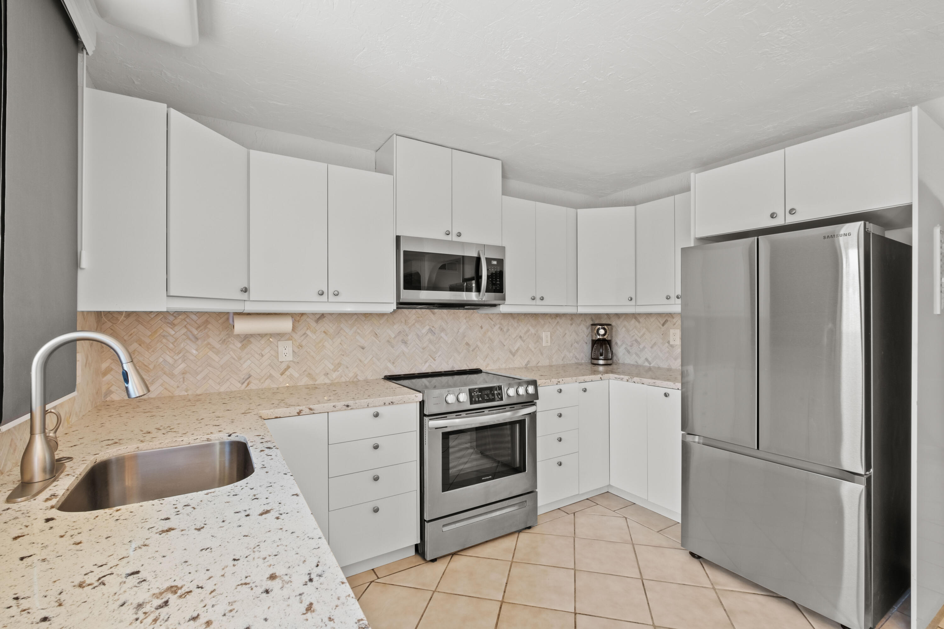 1268 Ramon Road, Unit 61 Palm Springs, CA 92264 - Photo 5 of 18 a kitchen with white cabinets and stainless steel appliances