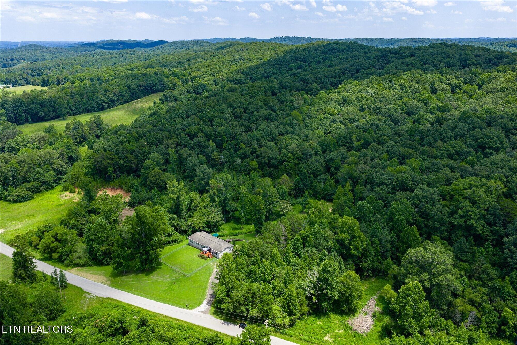 2025 Shiloh Road Decatur, TN 37322 - Photo 43 of 48 a view of a lush green outdoor space with a house in the background