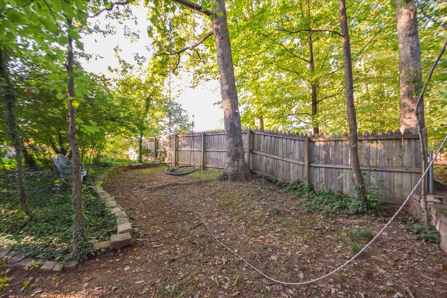 3060 Sedgefield Road Southwest Roanoke, VA 24018 - Photo 39 of 39 a view of a backyard with large trees and wooden fence