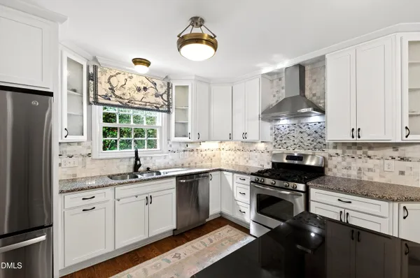a kitchen with a dining table chairs and wooden floor
