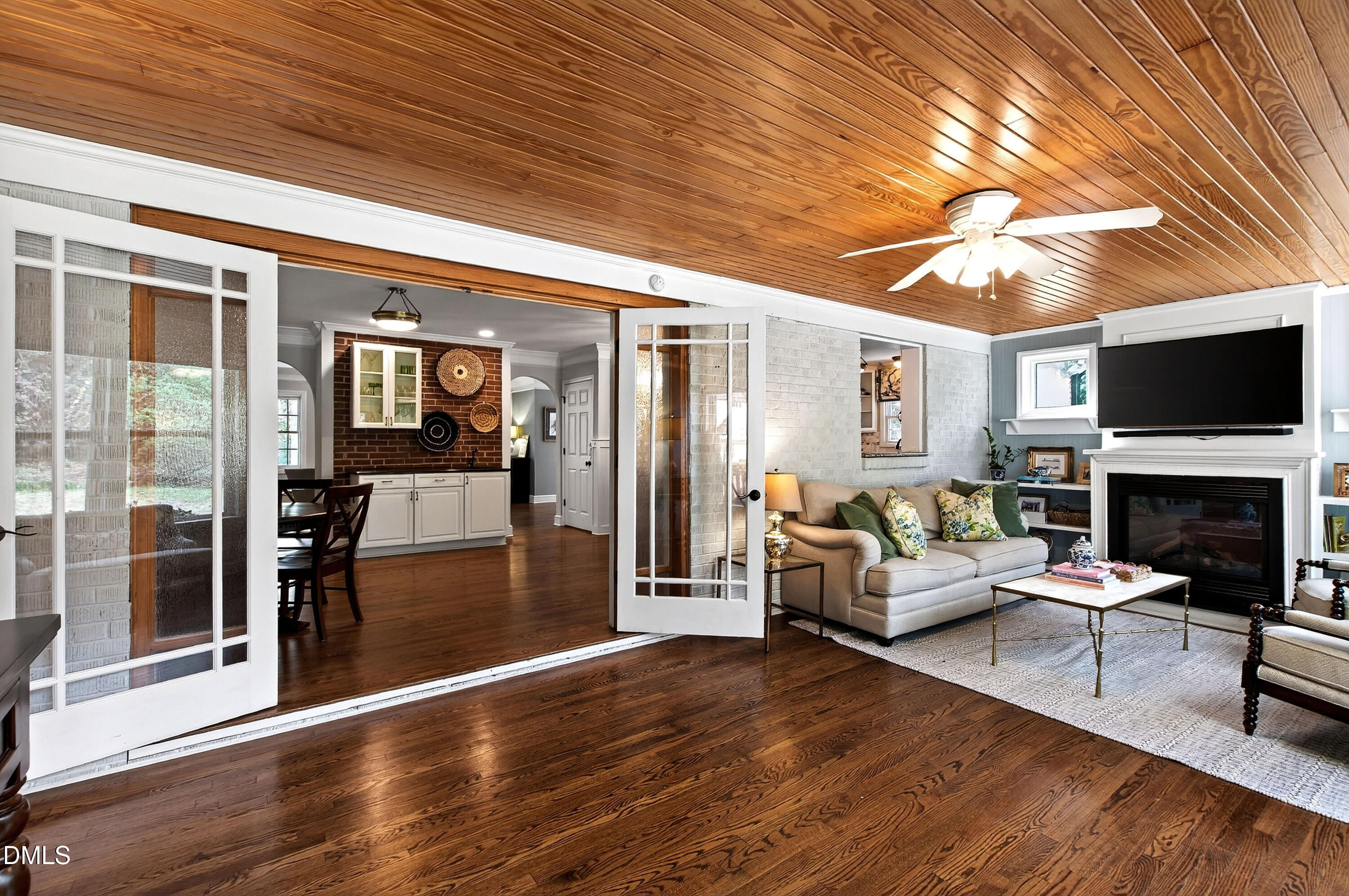 1205 Canterbury Road Raleigh, NC 27608 - Photo 18 of 48 a living room with furniture a fireplace and a flat screen tv