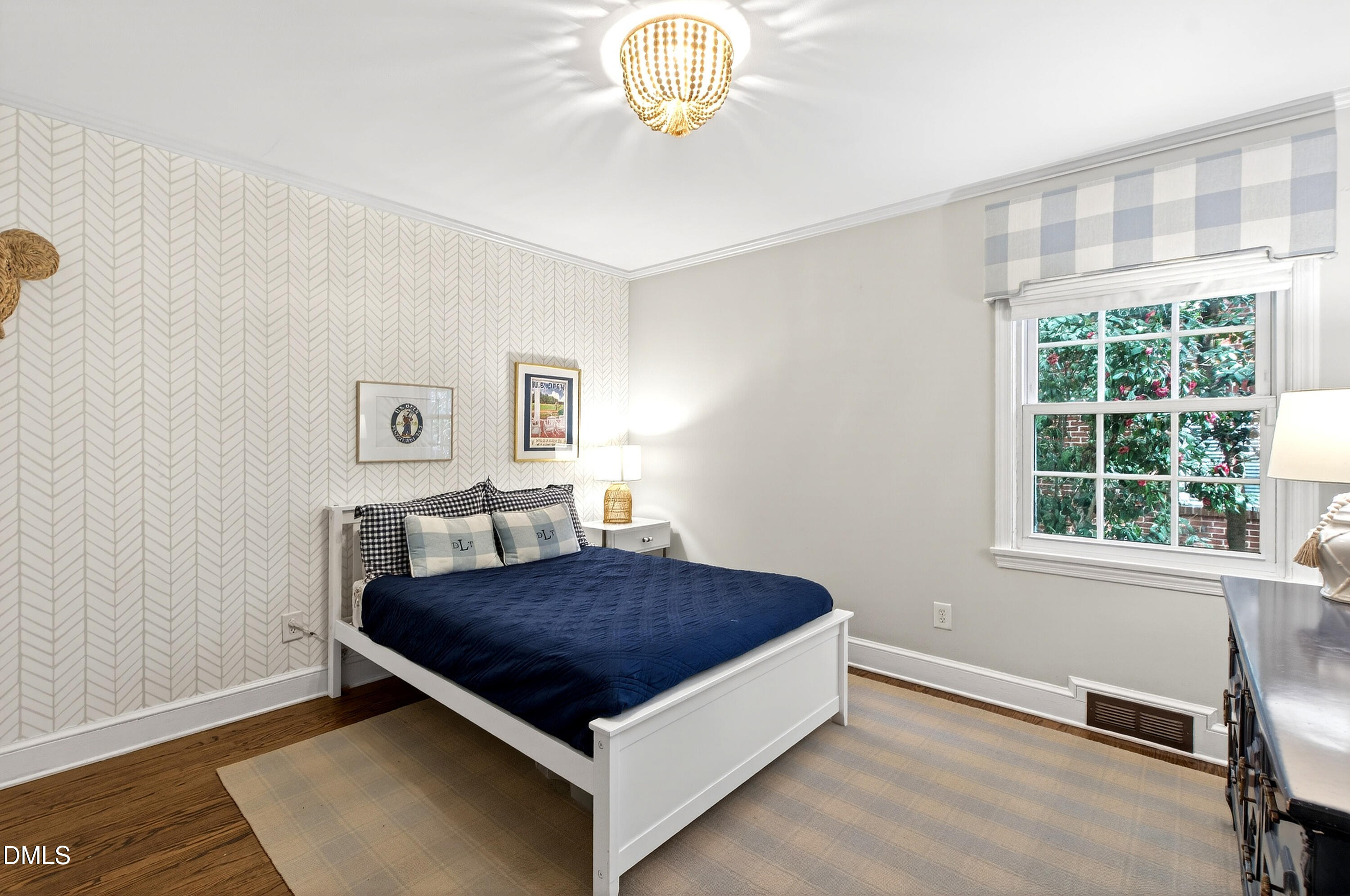 1205 Canterbury Road Raleigh, NC 27608 - Photo 28 of 48 a bedroom with a bed a chandelier and a window