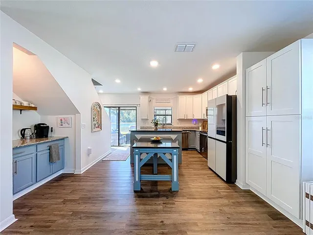 a kitchen with kitchen island granite countertop a sink stove microwave and refrigerator