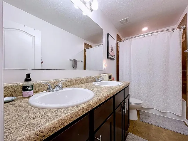 a bedroom with a bed and painting on the wall