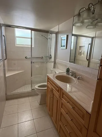 a bathroom with a granite countertop sink a toilet and a mirror