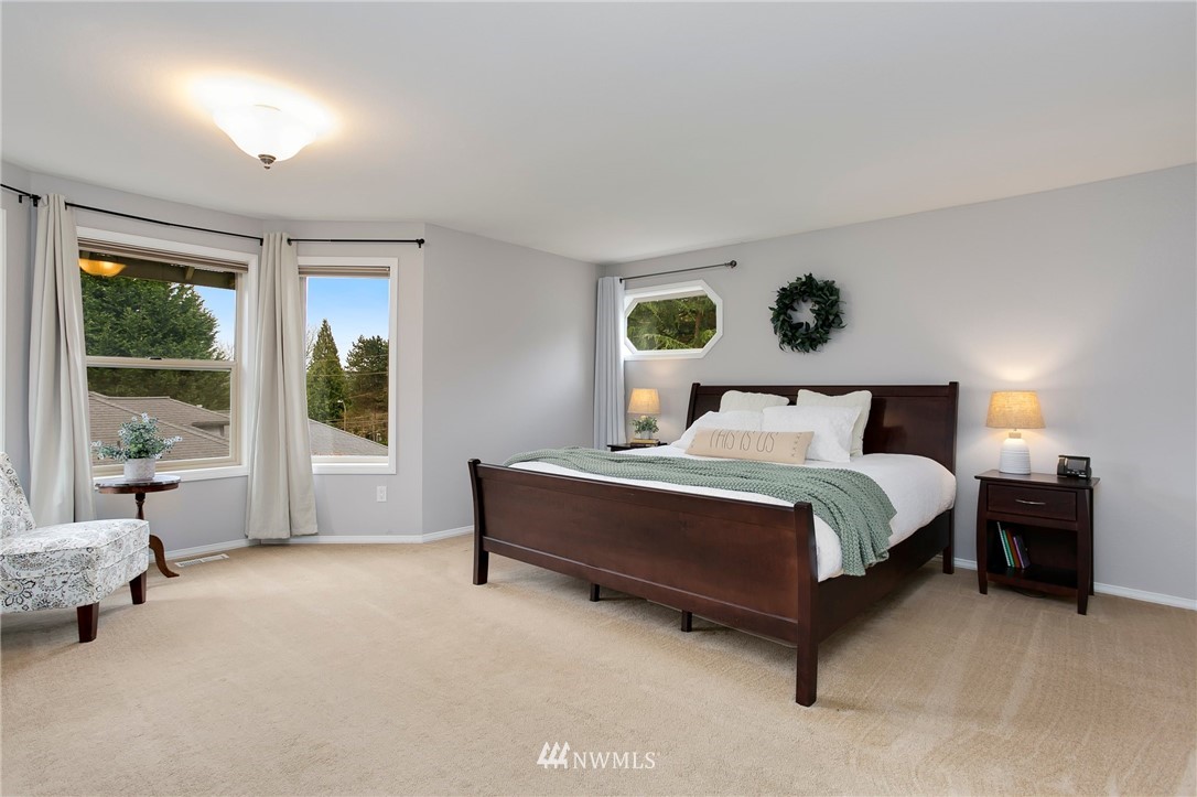 4521 244th Street Southeast Bothell, WA 98021 - Photo 12 of 38 a spacious bedroom with a bed and glass window