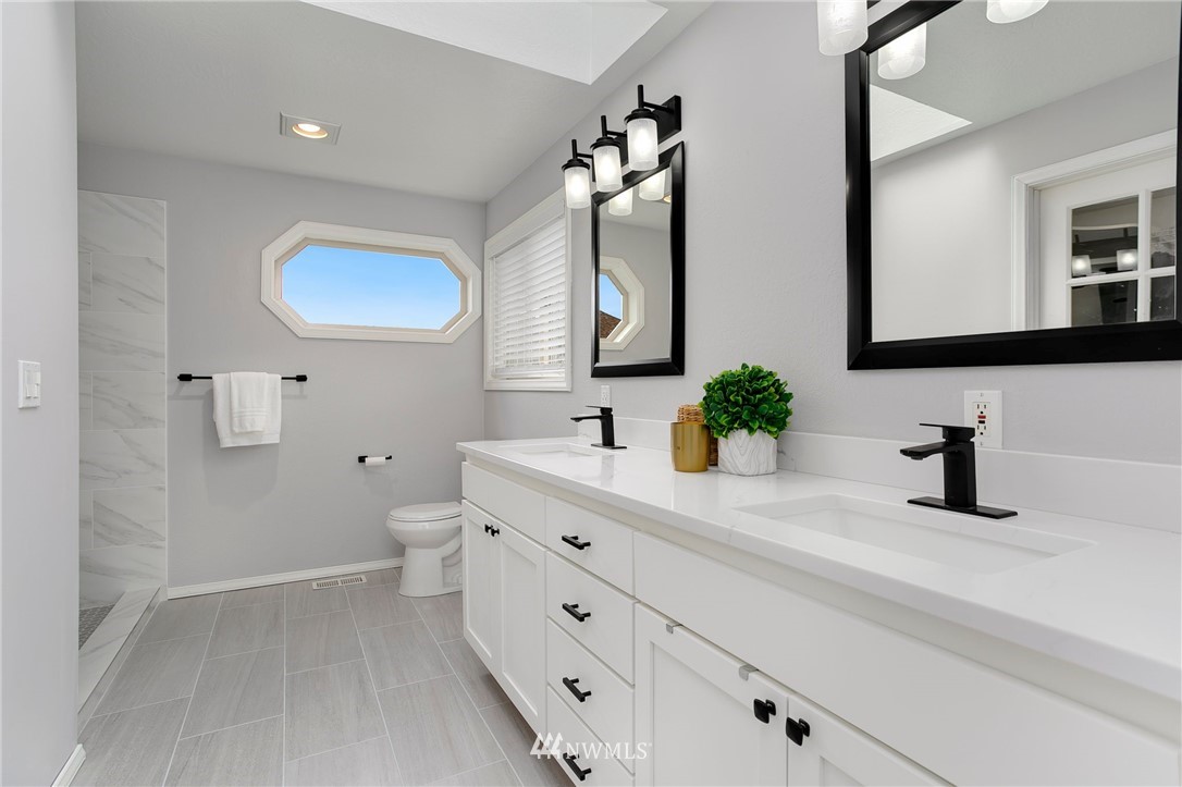 4521 244th Street Southeast Bothell, WA 98021 - Photo 14 of 38 a bathroom with a double vanity sink mirror and toilet