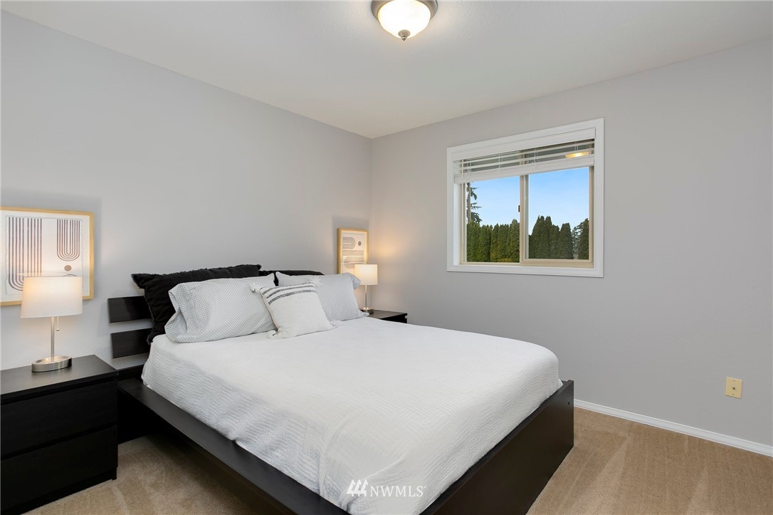 4521 244th Street Southeast Bothell, WA 98021 - Photo 16 of 38 a bedroom with a bed and a lamp