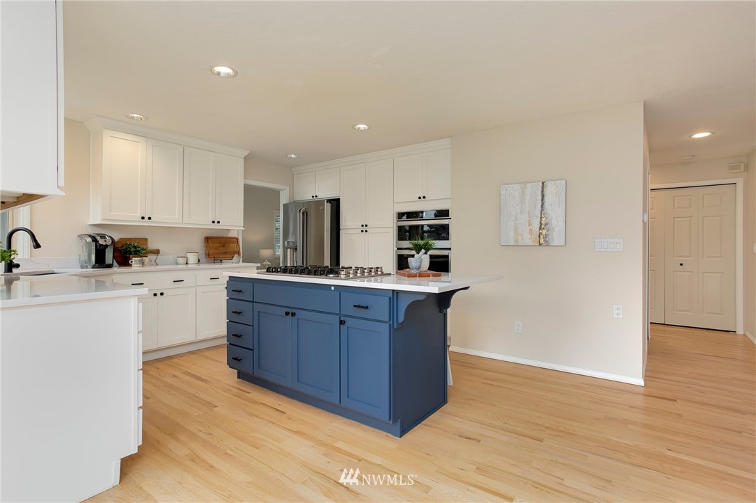4521 244th Street Southeast Bothell, WA 98021 - Photo 10 of 38 a kitchen with wooden floors and white cabinets