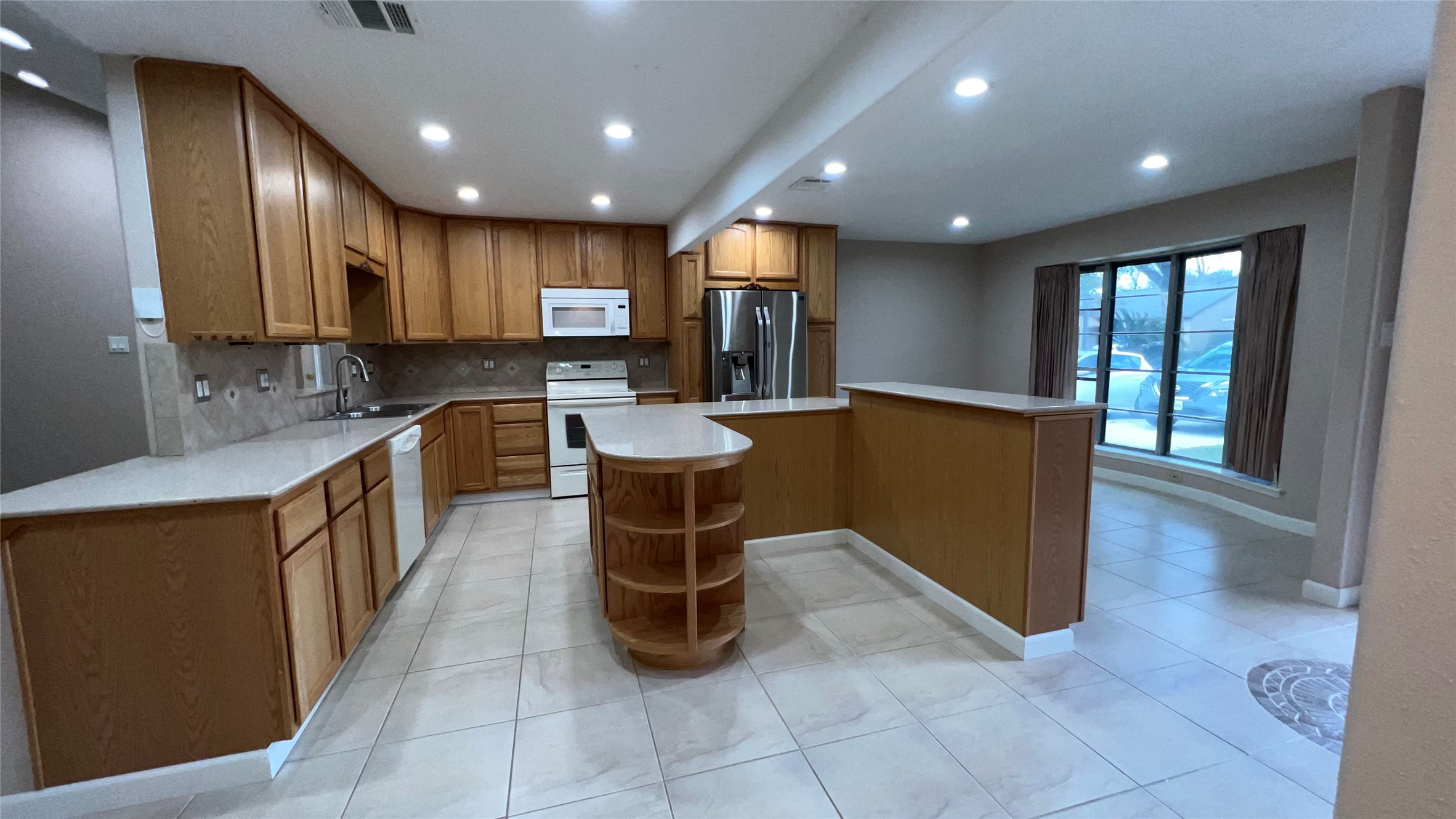 6615 Deer Ridge Lane Houston, TX 77086 - Photo 10 of 38 a kitchen with stainless steel appliances granite countertop a sink counter space cabinets and a large window