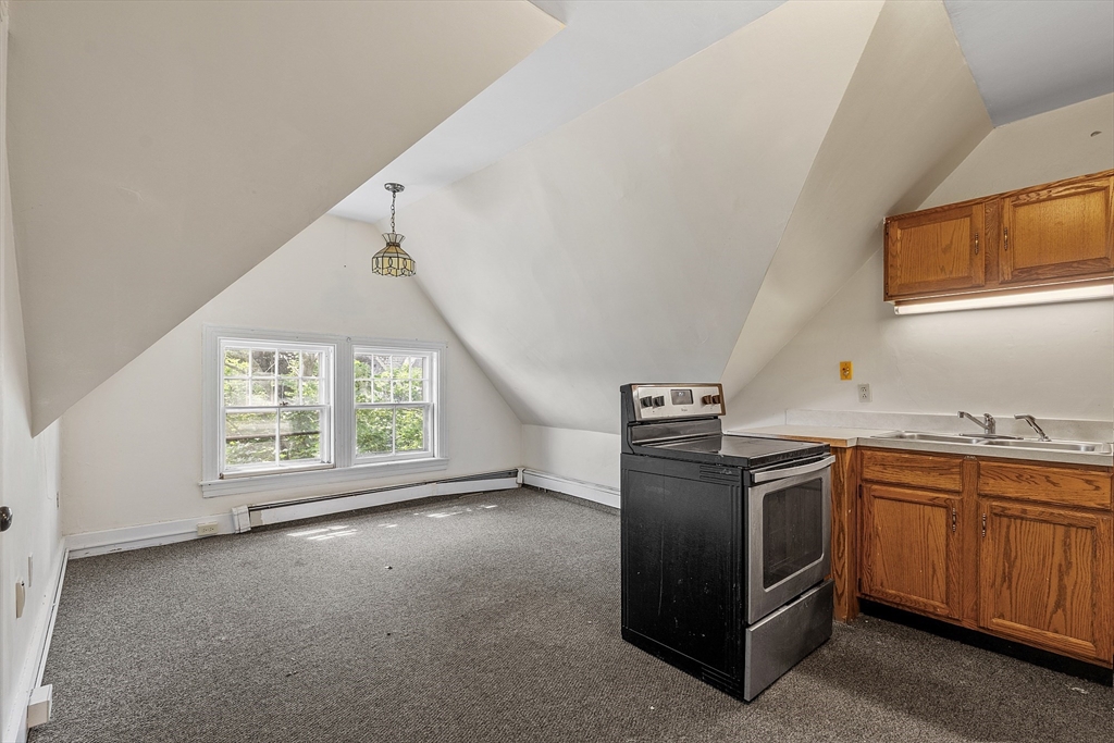 52 Cedar Street Worcester, MA 01609 - Photo 25 of 36 a kitchen with stainless steel appliances granite countertop a sink stove and refrigerator