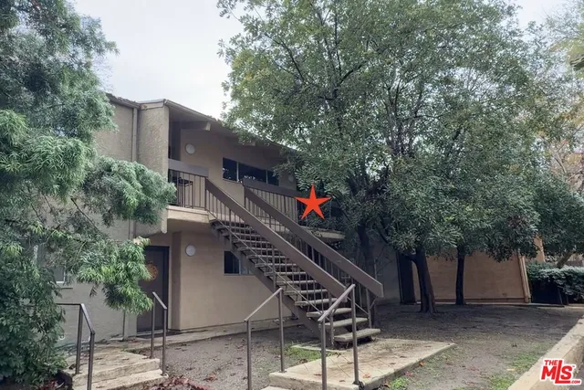 a front view of a house with a tree