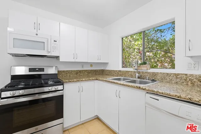a kitchen with granite countertop a stove a sink and a granite counter tops