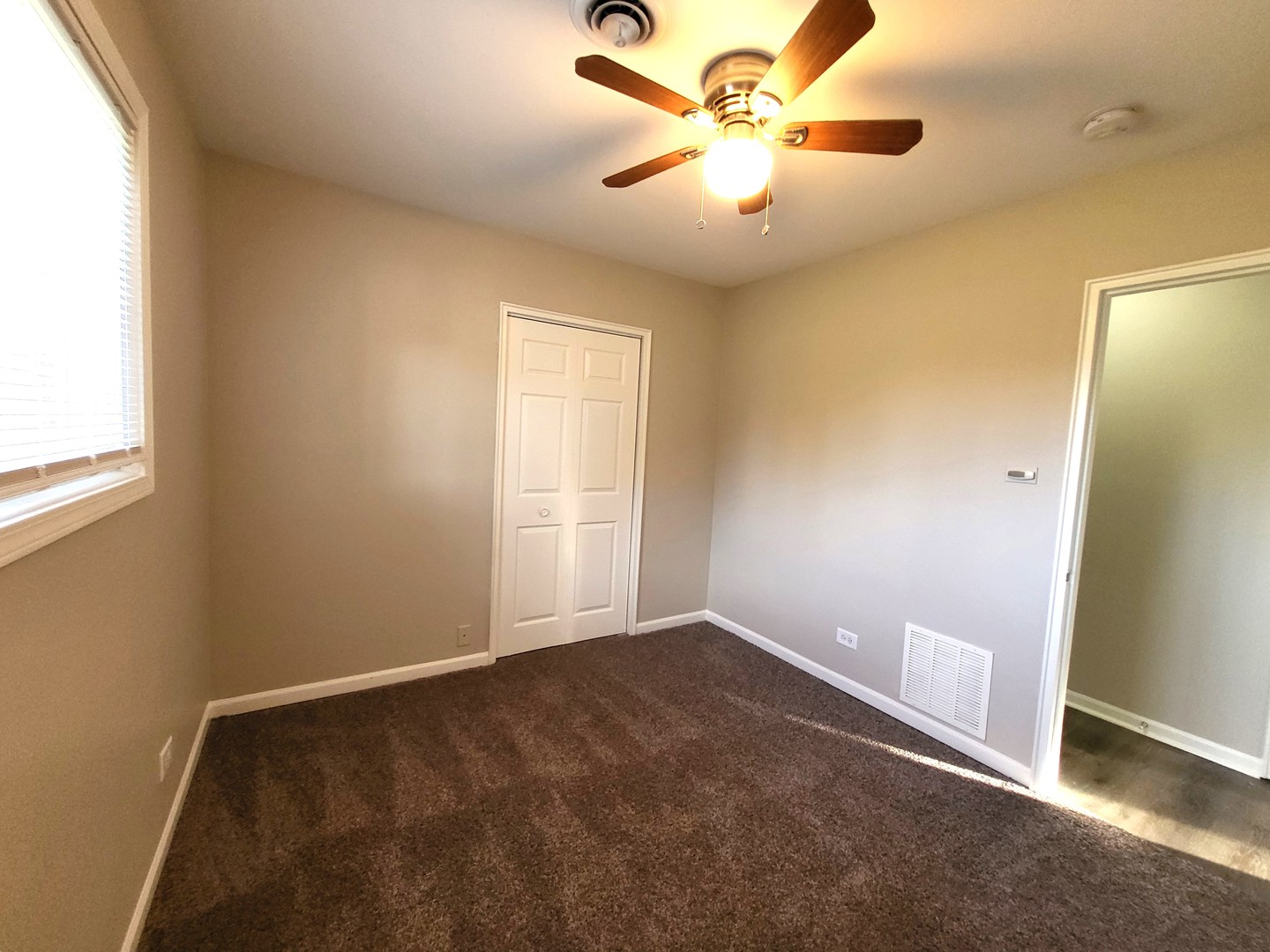 111 East 13th Street Lombard, IL 60148 - Photo 21 of 24 an empty room with a window and a fan