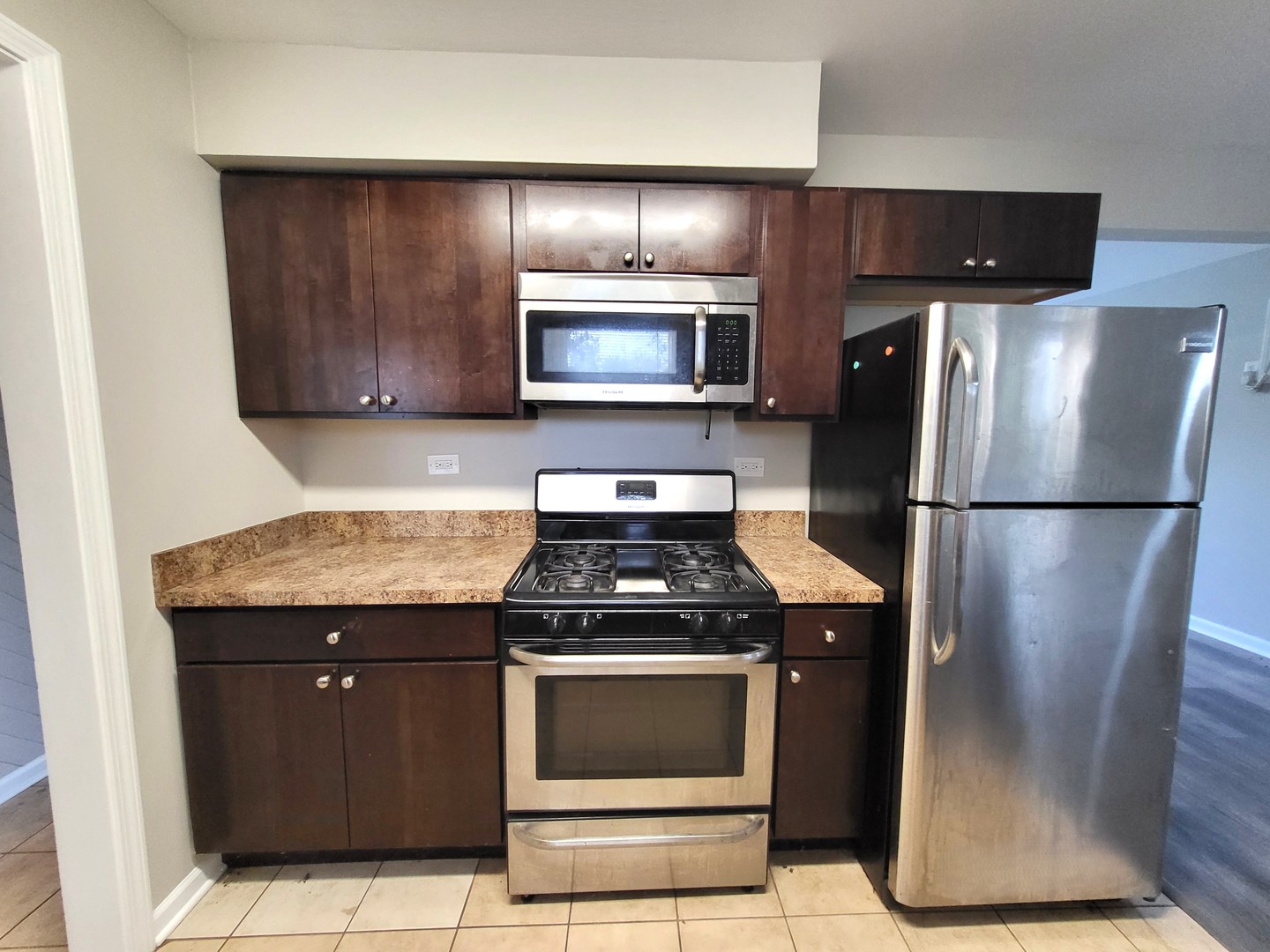 111 East 13th Street Lombard, IL 60148 - Photo 7 of 24 a kitchen with granite countertop wooden cabinets and stainless steel appliances