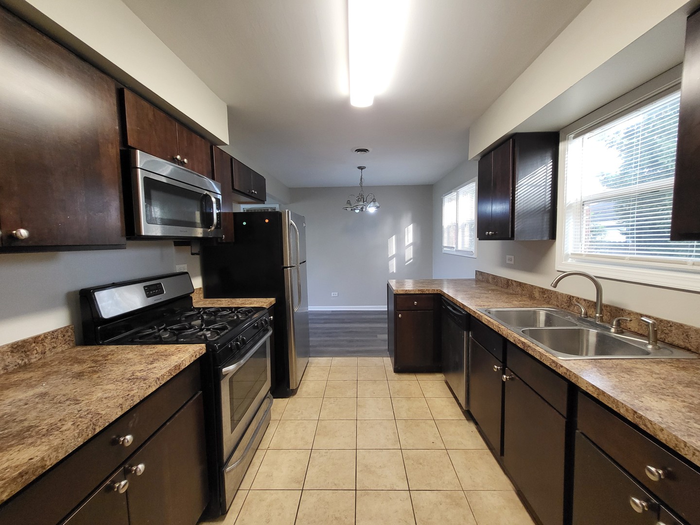 111 East 13th Street Lombard, IL 60148 - Photo 8 of 24 a kitchen with stainless steel appliances granite countertop a sink stove and cabinets
