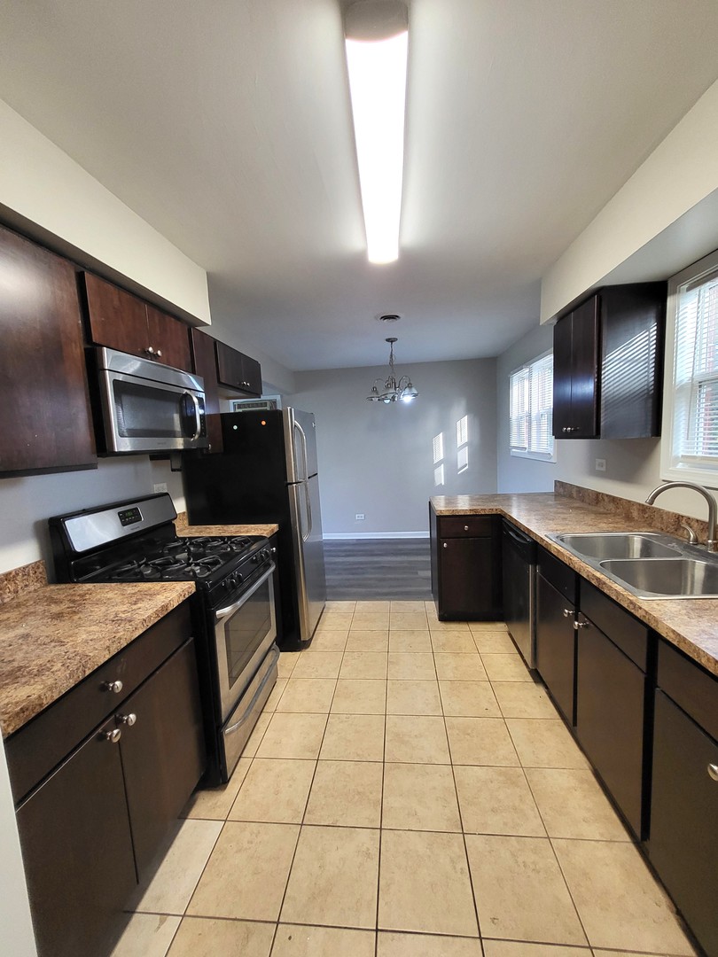 111 East 13th Street Lombard, IL 60148 - Photo 10 of 24 a large kitchen with stainless steel appliances granite countertop a sink and cabinets
